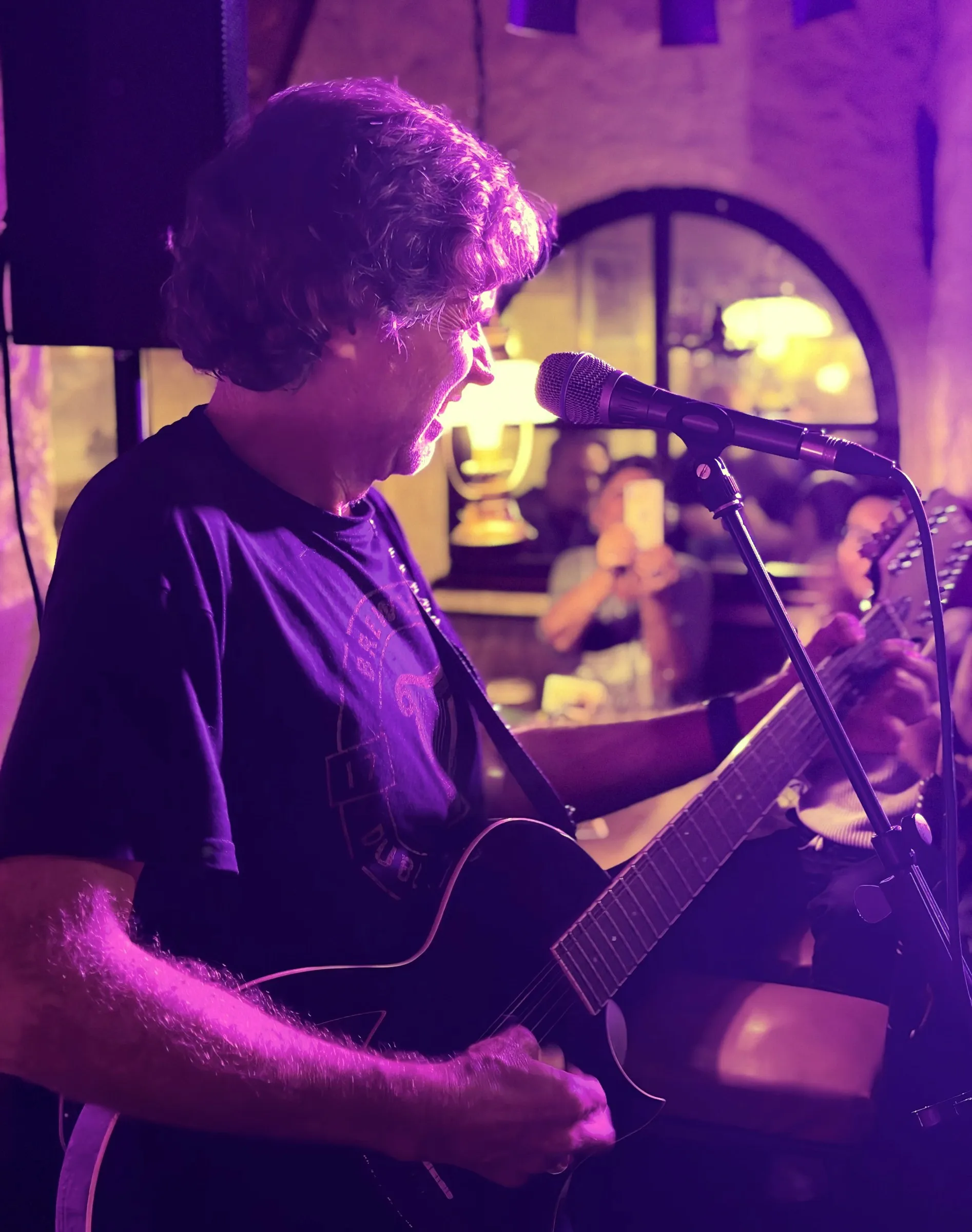Walt singt mit Gitarre im Bühnenlicht