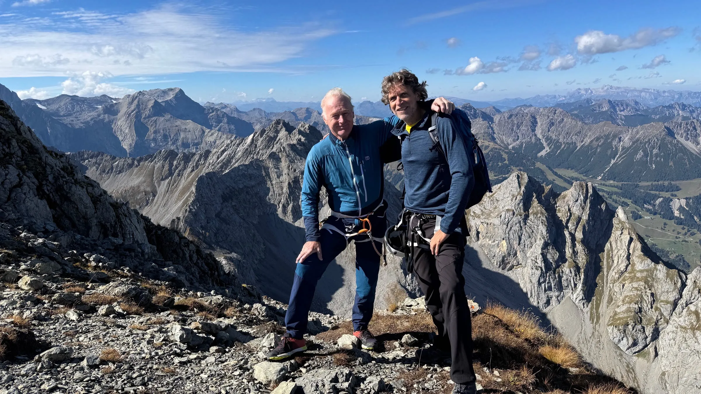 Walt mit einem Bergkameraden in Klettergurten am Gipfel der Zimba, dahinter die Gipfel des Rätikon